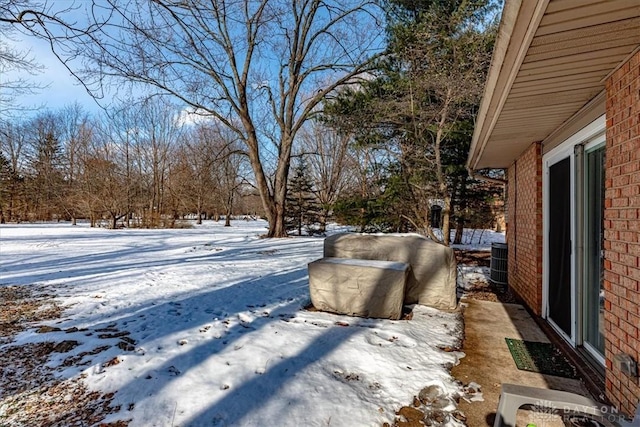 snowy yard featuring central AC unit