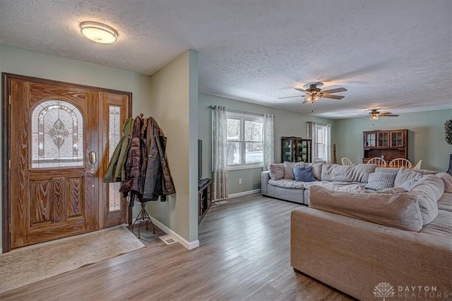 entrance foyer with ceiling fan, light hardwood / wood-style floors, and a textured ceiling