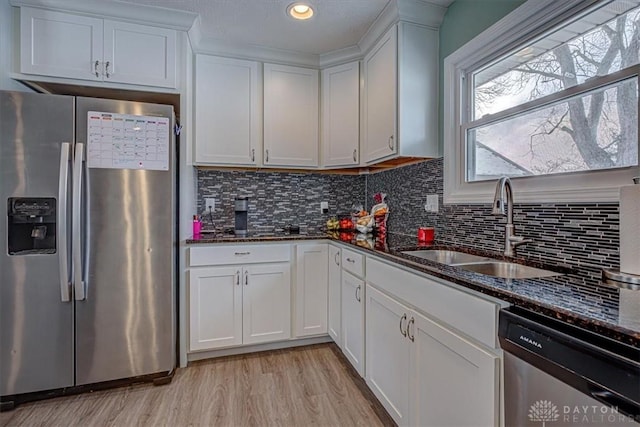 kitchen featuring white cabinetry, appliances with stainless steel finishes, sink, and dark stone counters