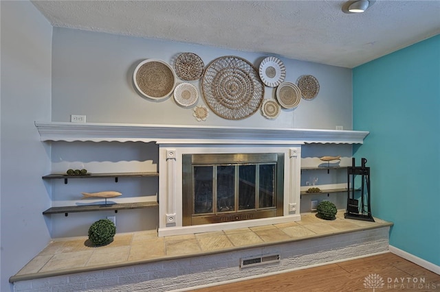 interior details featuring hardwood / wood-style flooring, a fireplace, and a textured ceiling