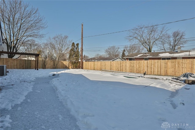 yard layered in snow featuring central air condition unit