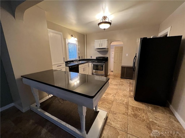 kitchen with sink, electric range, white cabinets, black fridge, and kitchen peninsula