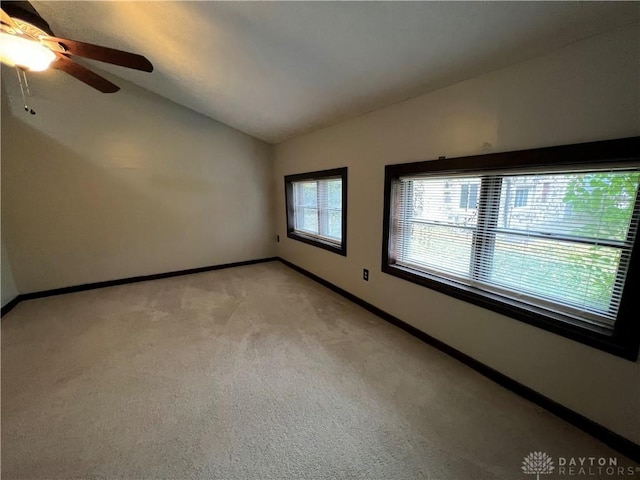 carpeted empty room featuring vaulted ceiling