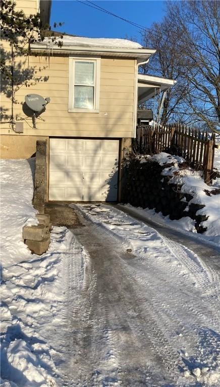 view of snowy exterior featuring a garage