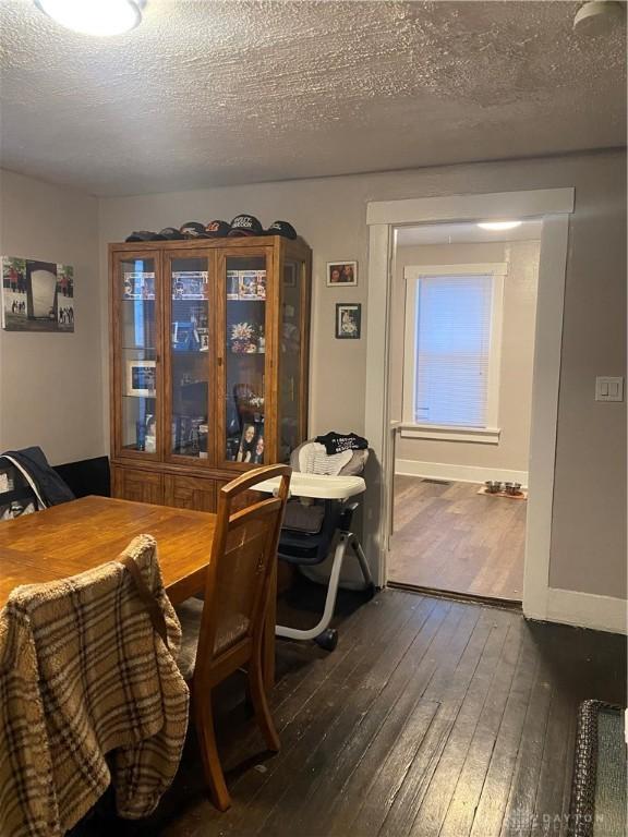 dining space featuring dark hardwood / wood-style floors and a textured ceiling