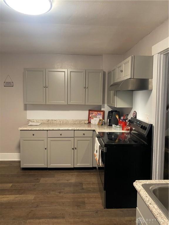 kitchen with dark hardwood / wood-style flooring, black electric range oven, gray cabinetry, and sink