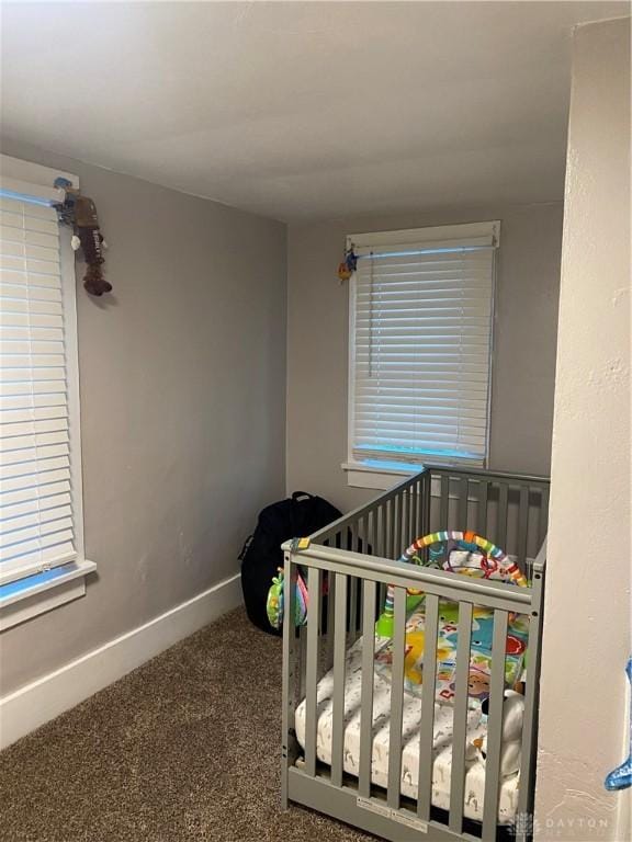 bedroom with a crib and carpet flooring