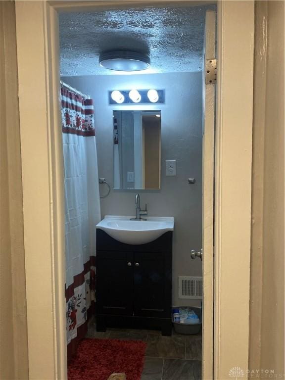 bathroom featuring vanity and a textured ceiling