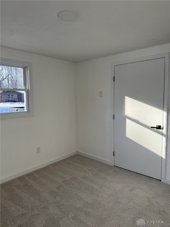 unfurnished room featuring light colored carpet