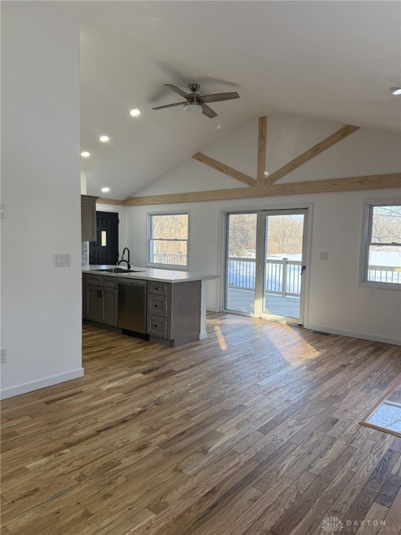 kitchen featuring sink, vaulted ceiling, stainless steel dishwasher, dark hardwood / wood-style flooring, and ceiling fan