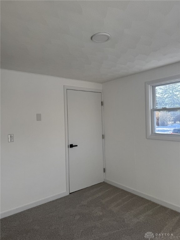 empty room featuring dark colored carpet