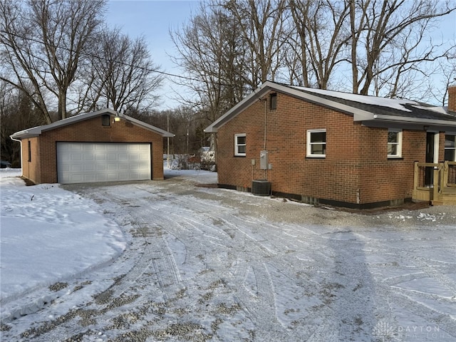 snow covered property with an outbuilding and a garage