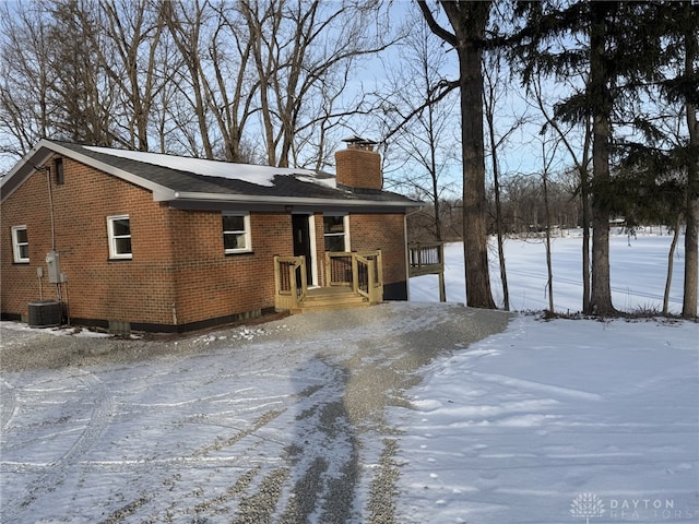 snow covered house with central air condition unit