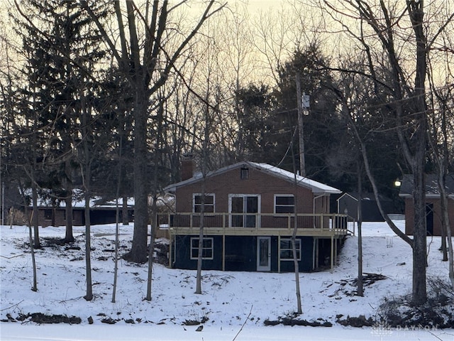 snow covered property with a wooden deck