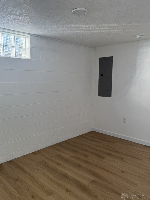 spare room with electric panel, hardwood / wood-style floors, and a textured ceiling