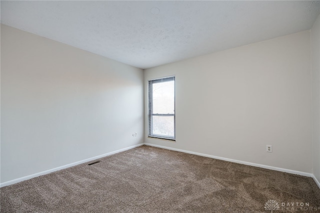 spare room featuring carpet flooring and a textured ceiling