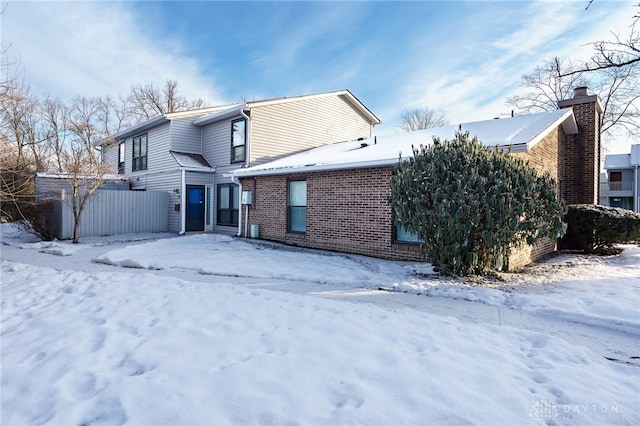 view of snow covered rear of property