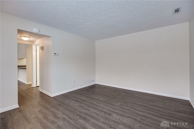 unfurnished room with dark hardwood / wood-style flooring and a textured ceiling