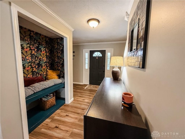 interior space featuring ornamental molding, hardwood / wood-style floors, and a textured ceiling