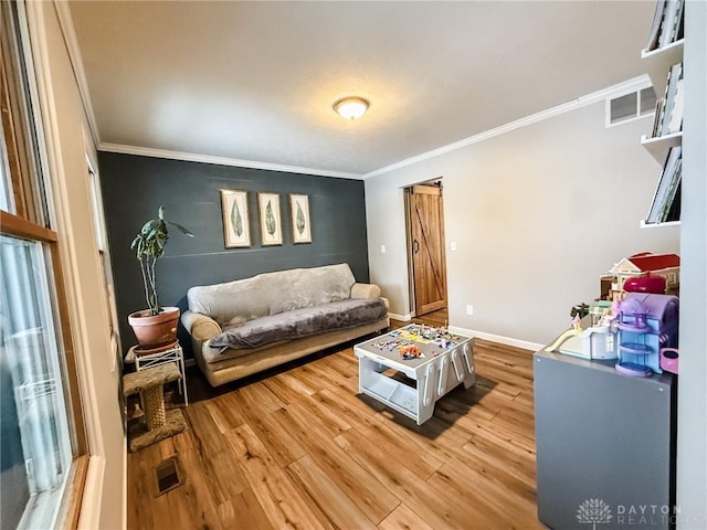 living room with ornamental molding and light hardwood / wood-style floors