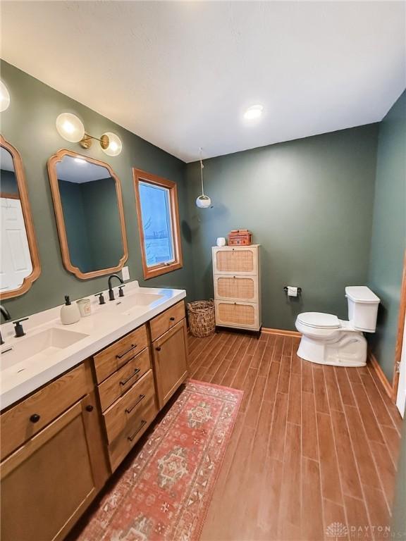 bathroom with hardwood / wood-style flooring, vanity, and toilet