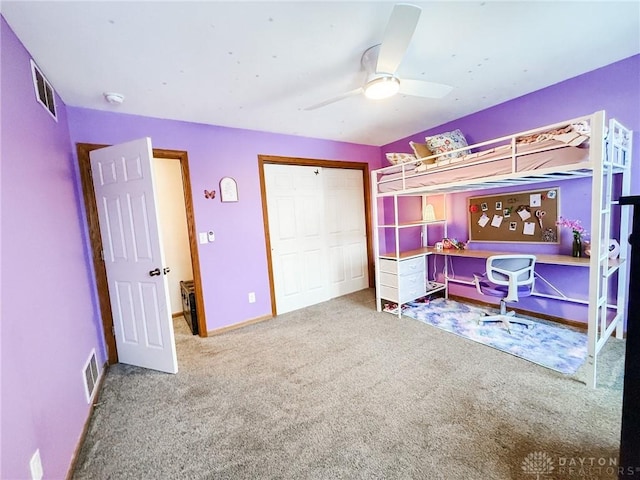 carpeted bedroom with ceiling fan and a closet