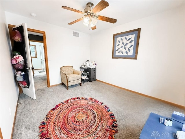 sitting room with ceiling fan and carpet