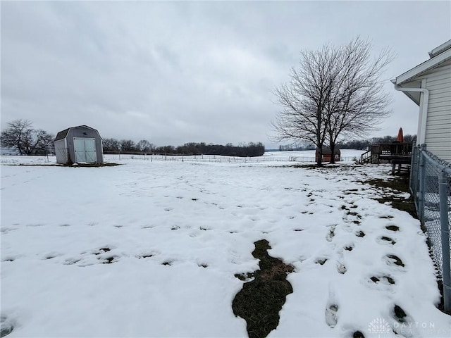 yard layered in snow with a storage shed