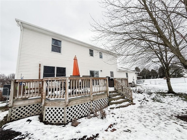 snow covered house with a wooden deck