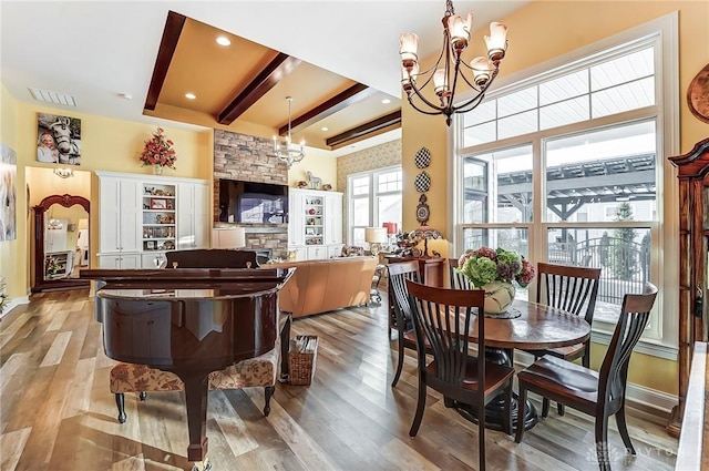 dining space featuring an inviting chandelier, light hardwood / wood-style floors, and beamed ceiling