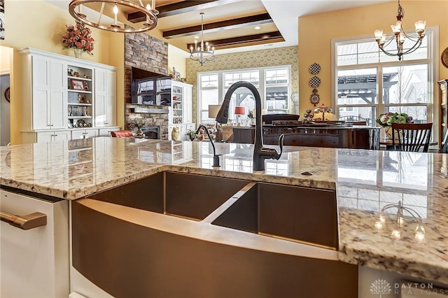 kitchen with an inviting chandelier, hanging light fixtures, and light stone countertops