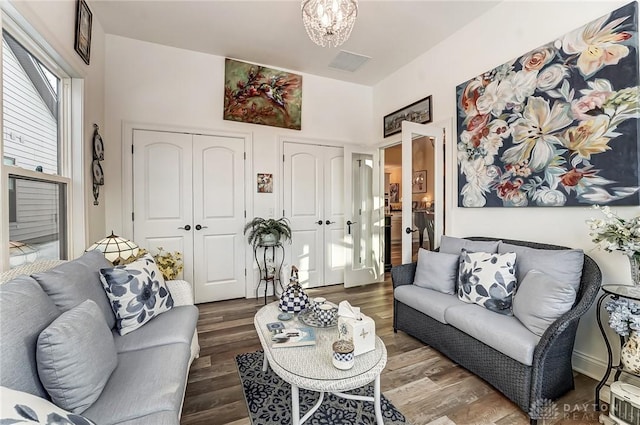 living room featuring wood-type flooring and a chandelier