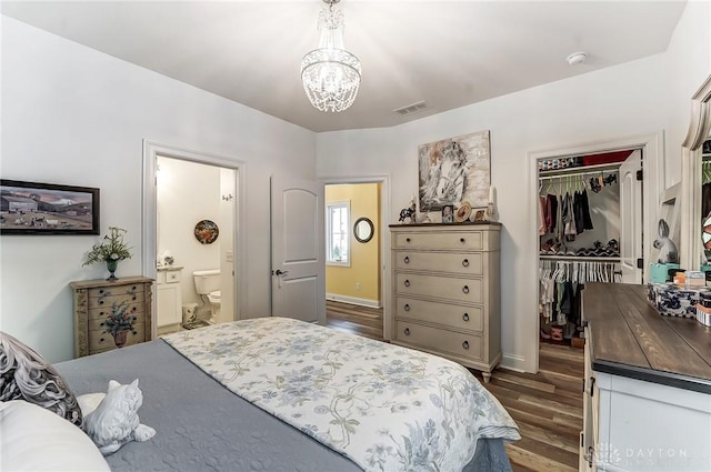 bedroom featuring an inviting chandelier, dark hardwood / wood-style floors, and a closet