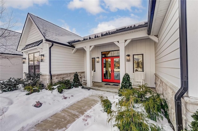 snow covered property entrance featuring french doors