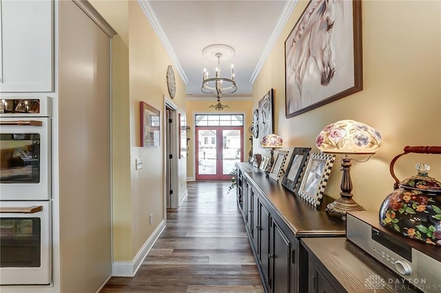 hallway featuring an inviting chandelier, crown molding, dark hardwood / wood-style floors, and french doors