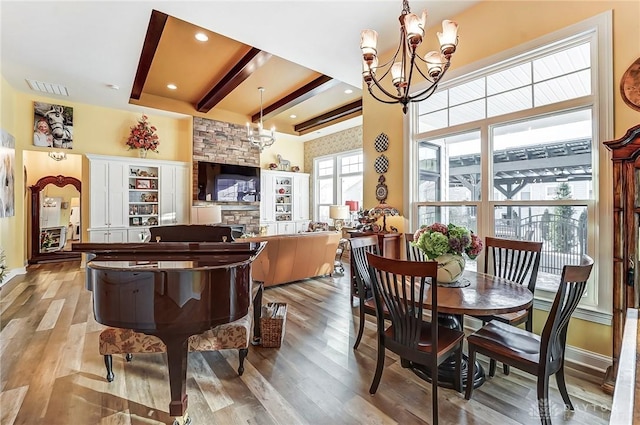 dining area with beam ceiling, light wood-type flooring, and an inviting chandelier