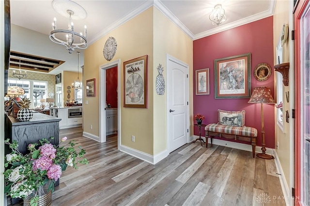 foyer entrance featuring an inviting chandelier, crown molding, and hardwood / wood-style floors