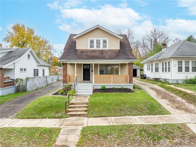 bungalow-style home featuring a front yard and covered porch