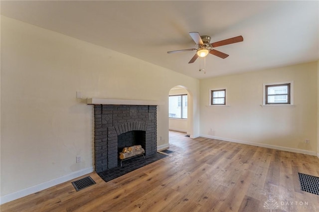 unfurnished living room featuring a brick fireplace, light hardwood / wood-style floors, and ceiling fan