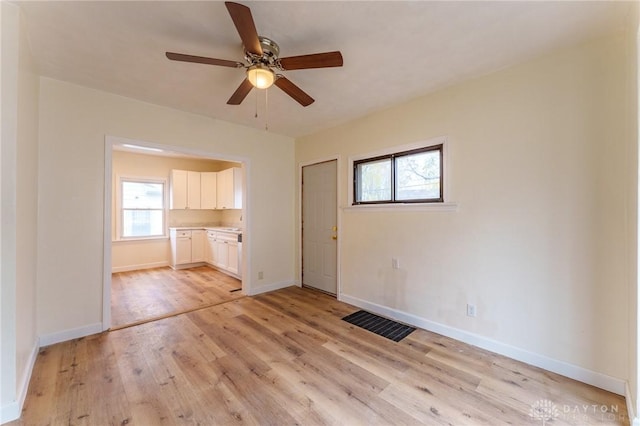 unfurnished living room featuring ceiling fan, plenty of natural light, and light hardwood / wood-style floors