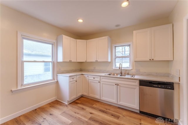 kitchen featuring white cabinetry, dishwasher, sink, and light wood-type flooring