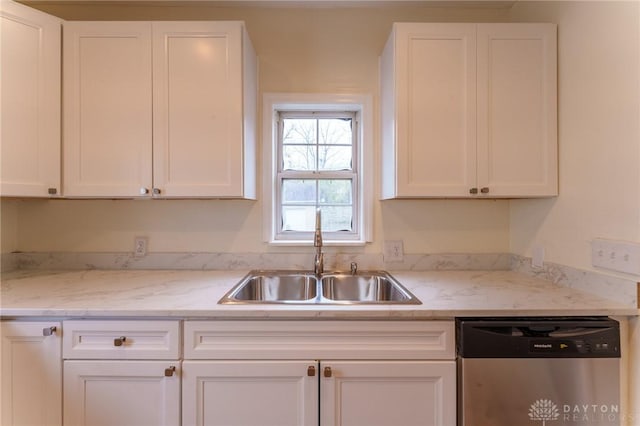 kitchen featuring white cabinetry, sink, stainless steel dishwasher, and light stone countertops