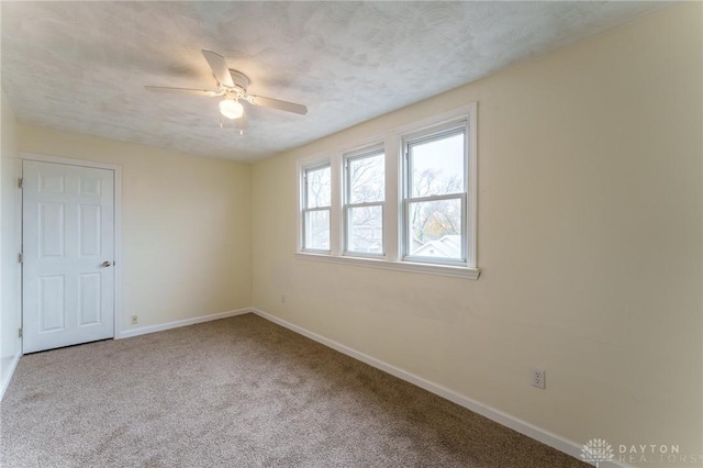 carpeted empty room with ceiling fan and a textured ceiling