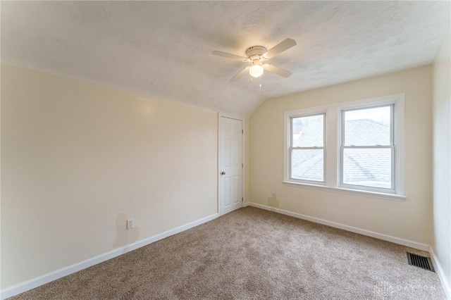 unfurnished room with vaulted ceiling, ceiling fan, and carpet flooring