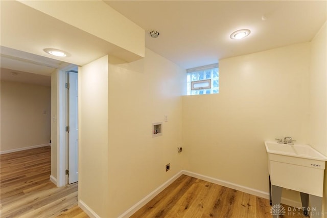 clothes washing area with sink, washer hookup, and light hardwood / wood-style floors