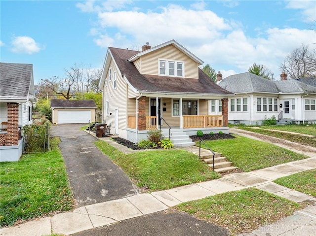 bungalow with an outbuilding, a garage, a front yard, and a porch