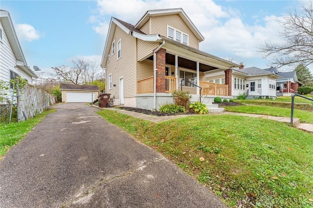 view of front of property featuring a porch, a garage, an outdoor structure, and a front yard