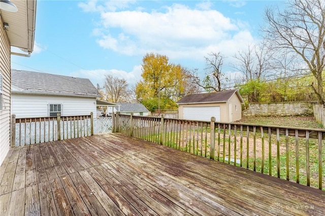 wooden deck featuring a garage, an outbuilding, and a lawn