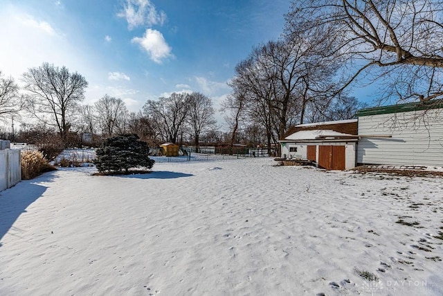 yard layered in snow with a storage unit