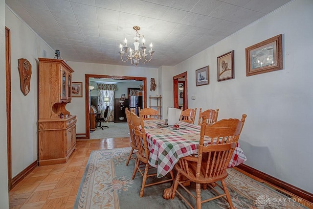 dining area featuring crown molding, light parquet floors, and a chandelier